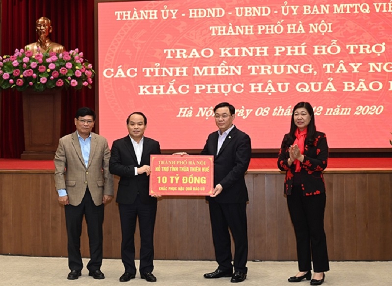 Bí thư Thành ủy Hà Nội Vương Đình Huệ và Chủ tịch Ủy ban MTTQ TP Nguyễn Lan Hương trao cho đại diện 12 tỉnh miền Trung, Tây Nguyên khoản hỗ trợ tổng số 91 tỷ đồng.